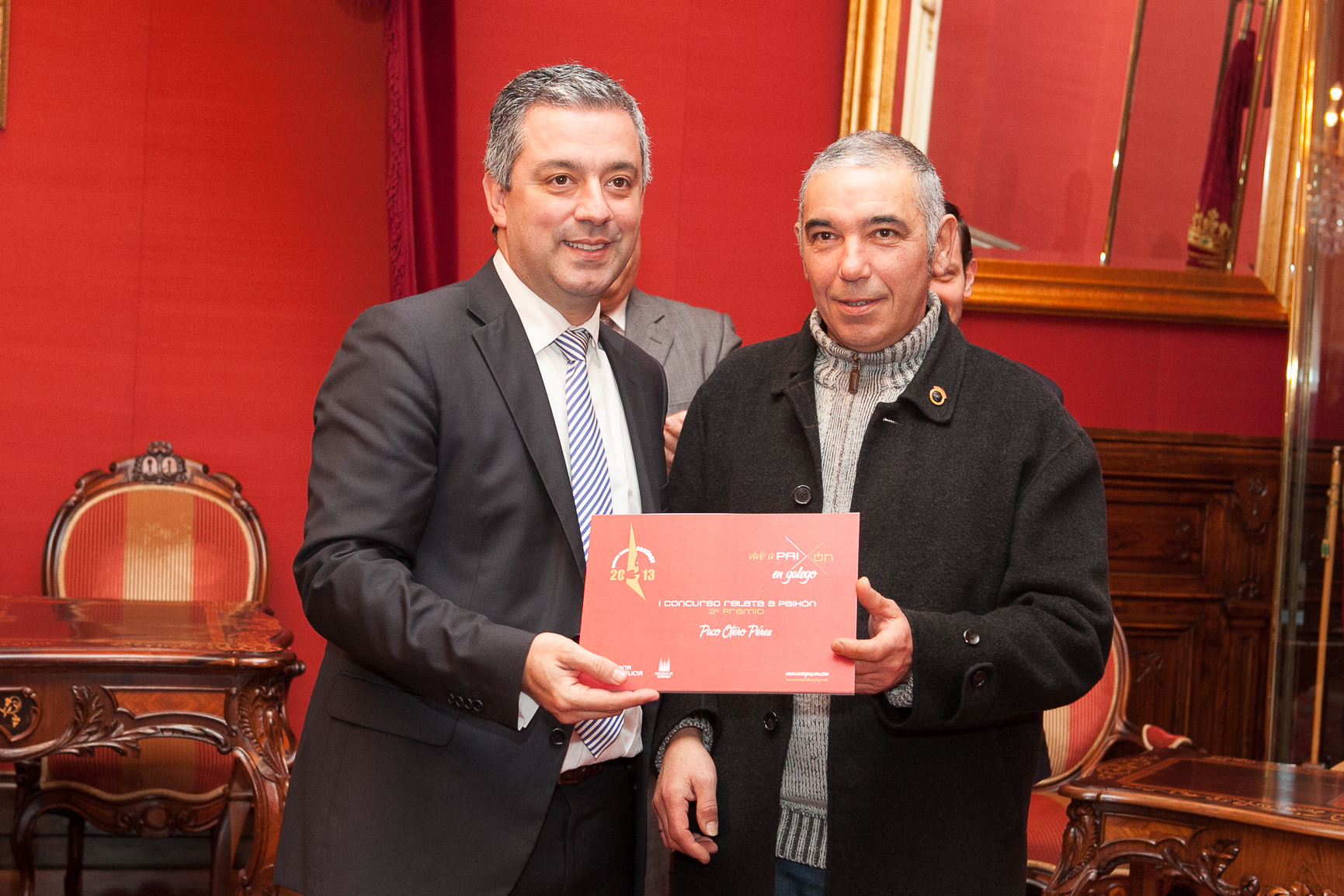 Paco Otero recibe o galardón como segundo clasificado de "Relata a Paixón" de mans do secretario xeral de Política Lingüística, Valentín García.