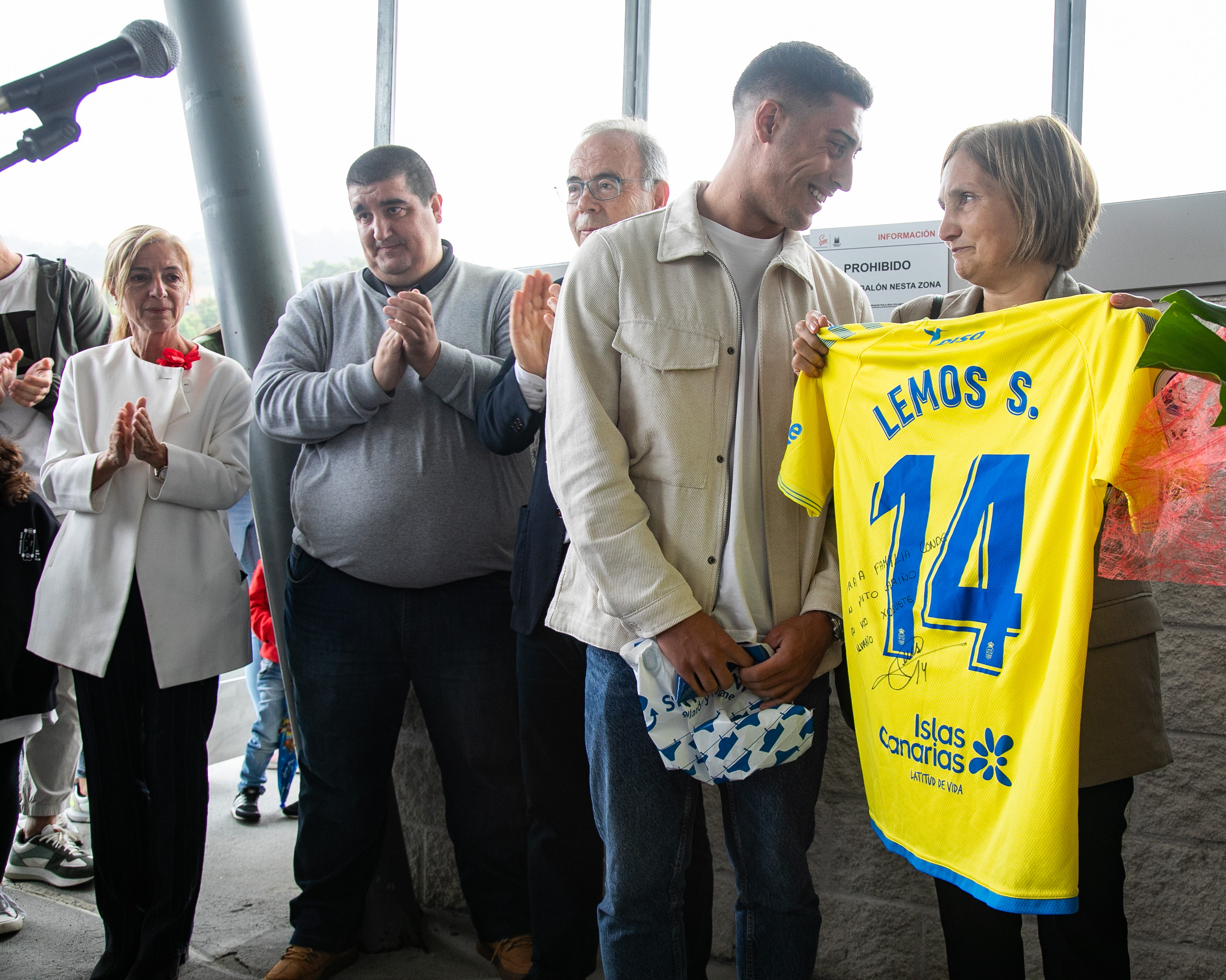 Un xogador do SD Villestro entrégalle unha camiseta asinada á viúva de Suso Conde